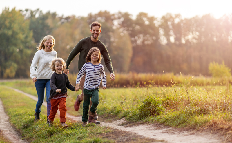 Image of family running through a field